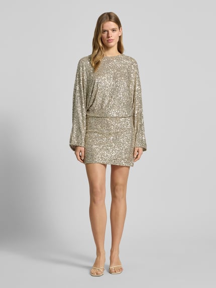 Frauenmodel trägt Minikleid mit Rundhalsausschnitt von Gina Tricot, taillierter Schnitt, Material-Mix mit Stretch-Anteil, Paillettenbesatz, blickdichtes Unterkleid, Farbe silber, Ganzkörperansicht von vorne.