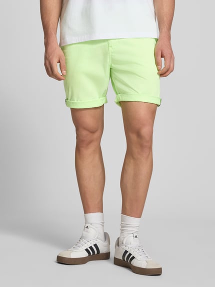 Männermodel trägt Regular Fit Shorts mit Münztasche von Superdry in Hellgrün, Baumwoll-Mix, Knopf-Reißverschluss, Ganzkörperansicht von vorne.