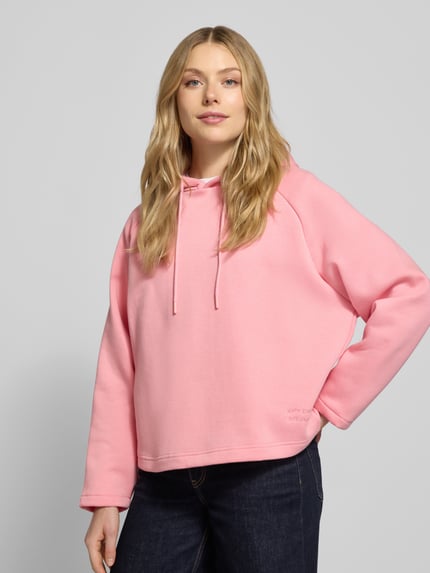 Frauenmodel trägt Hoodie mit Kapuze von Smith and Soul in Rosa, aus Baumwoll-Mix, locker geschnitten mit Tunnelzug und Statement-Stitching, Nahaufnahme Oberkörper.