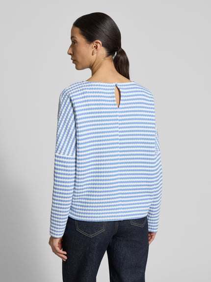 Frauenmodel trägt Relaxed Fit Pullover in Strick-Optik Modell 'Gresh' von OPUS aus reiner Baumwolle, gestreift in Blau und Weiß, Ganzkörperansicht Rückansicht.