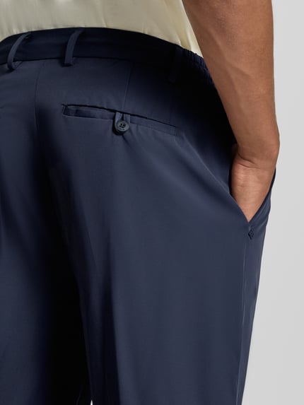 Männermodel trägt Anzughose mit Bügelfalte Modell 'PANTALACCIO' von MARKUP in Dunkelblau, Material-Mix, Nahaufnahme Hüfte, Rückansicht.