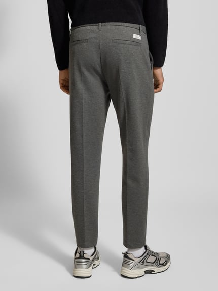 Männermodel draagt Regular Fit Bundfaltenhose mit Viskose-Anteil van Marc O'Polo Denim in effen grijs met steek- en achterzakken, Ganzkörperansicht Rückansicht.