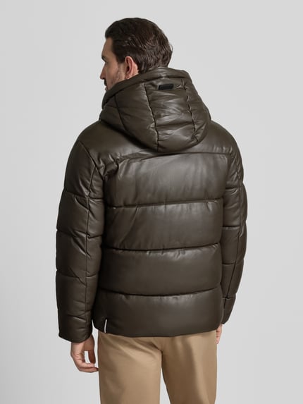 Männermodel trägt Regular Fit Steppjacke mit Logo-Patch Modell 'Coen' von khujo in Oliv, gefütterter Stehkragen, Kapuze, Ganzkörperansicht Rückansicht