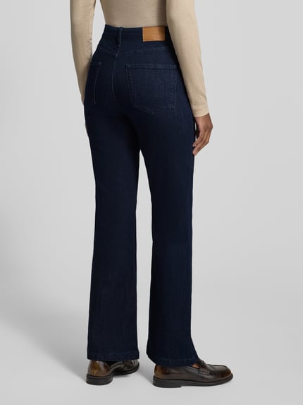Frauenmodel trägt Regular Fit Bootcut Jeans mit Teilungsnähten von S.OLIVER CASUAL in dunklem Denim mit sichtbaren Nähten, Ganzkörperansicht Rückansicht.