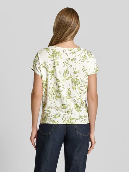 Vrouwenmodel draagt Relaxed Fit T-Shirt uit zachte viscose-mix van s.Oliver RED LABEL, allover bloemenprint, U-boothals, korte mouwen, relaxed fit, bloemenpatroon, wit met groene tinten, detailrijke textuur, productfoto, volledige rugaanzicht.
