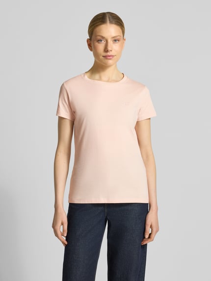 Frauenmodel trägt Regular Fit T-Shirt aus reiner Baumwolle Modell 'ESOGO' von BOSS Orange in zartem Rosa, unifarben, Rundhals, Label Schriftzug, kurzarm, Ganzkörperansicht von vorne.
