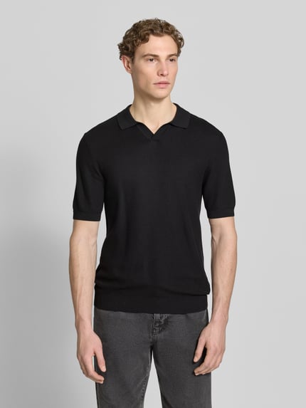 Männermodel trägt Slim Fit Poloshirt mit Viskose-Anteil von Roy Robson in Schwarz, Strukturmuster, elastische Abschlüsse, Ganzkörperansicht von vorne.