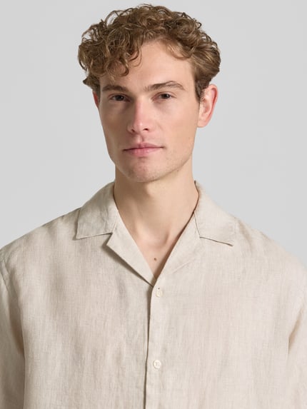 Männermodel trägt Regular Fit Leinenhemd Modell 'LAWRENCE' von Jack & Jones Premium, Reverskragen, Knopfleiste, Reine Leinen, Nahaufnahme Oberkörper.