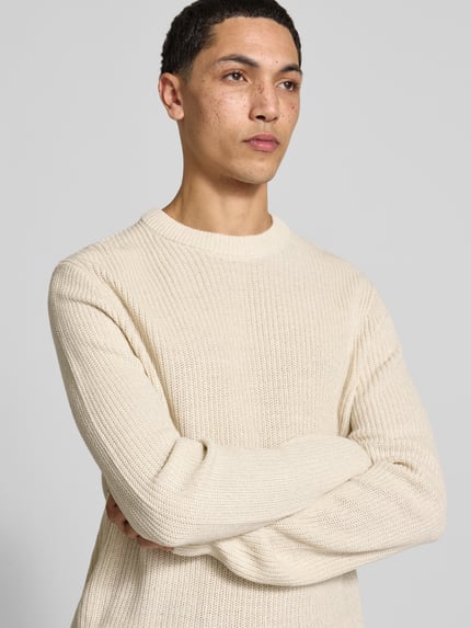 Männermodel trägt Pullover mit gerippten Abschlüssen Modell 'ONSJONAS' von ONLY, beigefarbene Strickoptik, Nahaufnahme Oberkörper.