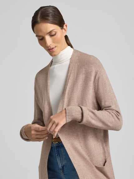 Frauenmodel trägt Relaxed Fit Strickjacke aus Viskose-Mix mit Eingrifftaschen von Christian Berg Woman in Beige mit gerippten Abschlüssen, Nahaufnahme Oberkörper. Damen Strickjacke, Viskose-Mix, relaxed Fit, Eingrifftaschen, langärmliges Design, Rückenlänge Gr. S: 80 cm, Ärmellänge Gr. S: 39 cm.