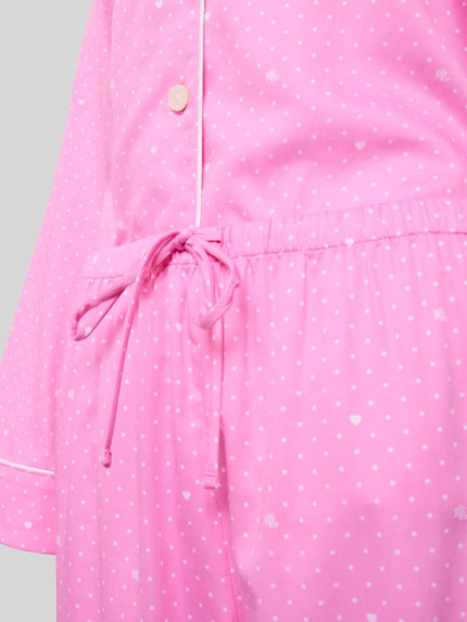 Vrouwenmodel draagt Pyjama aus Baumwoll-Viskose-Mix mit Reverskragen van Lauren Ralph Lauren in roze met witte stippen, detailopname taille. Regular fit, knoopsluiting, elastische tailleband met tunnelkoord.