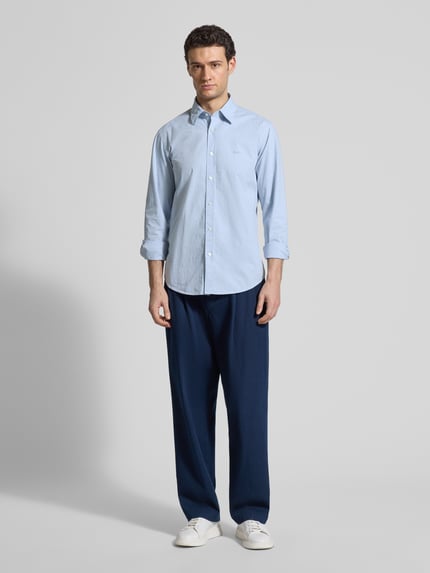 Männermodel trägt Regular Fit Freizeithemd aus Baumwoll-Mix Modell 'RELEGANT_6_M' von BOSS Orange, hellblau, gepunktet, Ganzkörperansicht von vorne.