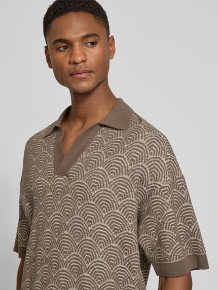Männermodel trägt Relaxed Fit Poloshirt mit V-Ausschnitt Modell 'LAURENZZO' von Drykorn im Allover-Look aus Baumwoll-Mix, Nahaufnahme Oberkörper. Rückenlänge bei Größe M: 67 cm.