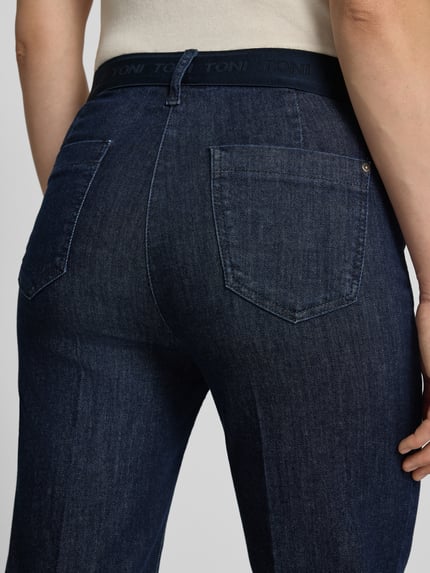Vrouwenmodel draagt donkerblauwe jeans met rechte pijpen en zichtbare zakken, Wide Fit Jeans uit mix van katoen en lyocell, model 'Jenny' van TONI, dames wide & loose fit jeans, detailopname rugaanzicht.