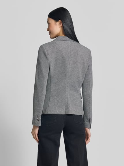 Vrouwenmodel draagt Slim Fit Kurzblazer met katoenmix model 'JULIA' van VERO MODA in grijs, rechte lijnen, effen textuur, volledige lichaamsfoto achteraan.