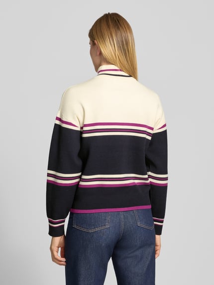 Frauenmodel trägt Troyer mit Après-Schriftzug von JAKE*S WOMAN CASUAL, mehrfarbig gestreift in Strickoptik, Ganzkörperansicht Rückansicht.