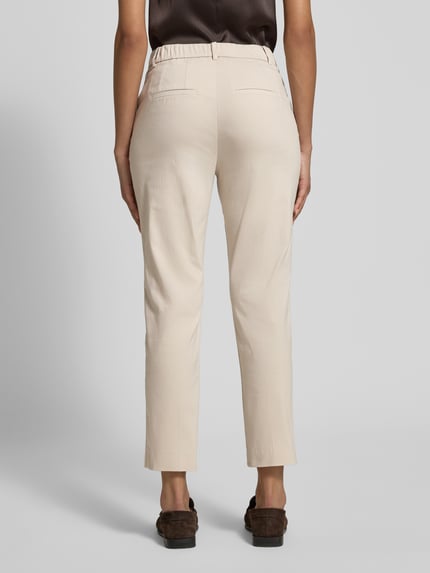 Vrouwenmodel draagt Hose in verkürzter Passform Modell Flour 2 van STEHMANN in beige katoenmix met stretch, steekzakken, verkorte pasvorm, bandwijdte maat 36: 40 cm, binnenbeenlengte maat 36: 67 cm, geheel van achteren.
