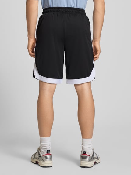 Männermodel trägt Relaxed Fit Shorts mit elastischem Bund von Pegador in Schwarz-Weiß mit Logo-Stitching und Eingrifftaschen, Ganzkörperansicht Rückansicht.