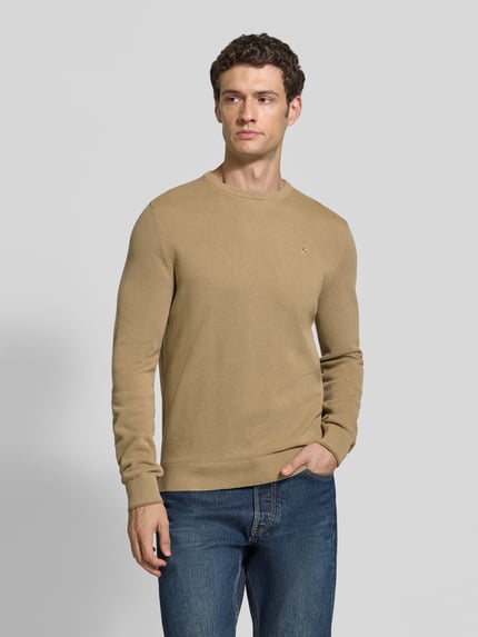 Männermodel trägt Regular Fit Strickpullover aus reiner Baumwolle mit Label-Detail von LERROS, Beige, glatte Textur, Ganzkörperansicht von vorne. Herren Strickpullover, elastische Abschlüsse, Rückenlänge 68 cm, Ärmellänge 69 cm.