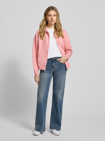 Frauenmodel trägt Oversized Sweatjacke mit Kapuze von Smith and Soul in Rosa, aus Baumwoll-Mix, mit Reißverschluss und Eingrifftaschen, Ganzkörperansicht von vorne.