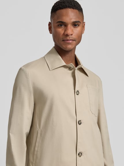 Männermodel trägt Regular Fit Hemdjacke mit Brusttasche von Manuel Ritz in Beige, Baumwoll-Mix mit Kentkragen, Knopfleiste, Nahaufnahme Oberkörper.