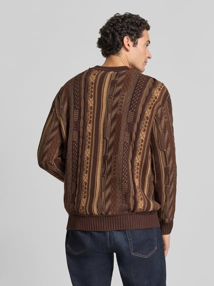 Männermodel trägt Regular Fit Strickpullover aus reiner Baumwolle von COLUCCI in Braun mit Muster, gerippte Abschlüsse, Ganzkörperansicht Rückansicht.