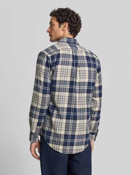 Męski model nosi Regular Fit Freizeithemd aus reiner Baumwolle von Polo Ralph Lauren w granatowo-kremową kratę, widok całej sylwetki z tyłu.
