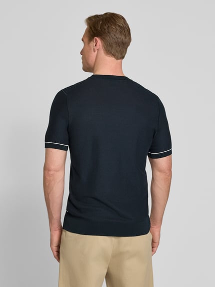 Männermodel trägt Regular Fit T-Shirt aus Strick Modell 'H-NALON' von BOSS in Strickoptik, Baumwoll-Mix, Ganzkörperansicht Rückansicht.