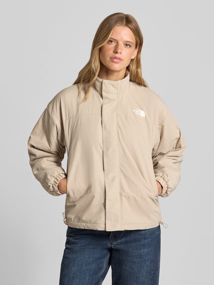 Frauenmodel trägt Jacke mit Wendefunktion Modell 'YUMIORI' von The North Face in Beige, Regular Fit, Stehkragen, Logo, Ganzkörperansicht von vorne. Rückenlänge bei Größe S: 62 cm, Schulterbreite: 52 cm, Brustweite: 57 cm, Ärmellänge: 57 cm.