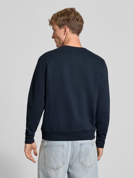 Männermodel trägt Regular Fit Sweatshirt aus Baumwoll-Mix mit Logo-Stickerei von Superdry, dunkelblau, glatte Struktur, Ganzkörperansicht Rückansicht.