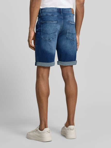 Männermodel trägt Bermudas im 5-Pocket-Design mit Aufschlag van Christian Berg Men, katoenmix met stretch, straight fit, ganzkörperansicht rückansicht.