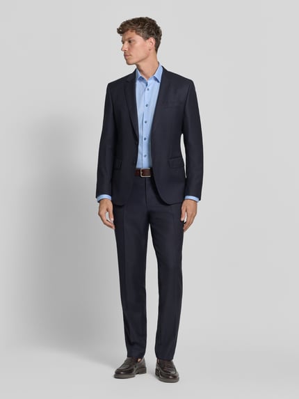 Männermodel trägt Regular Fit Businesshemd mit Brusttasche von OLYMP in Hellblau, feines Webmuster, Ganzkörperansicht von vorne.
