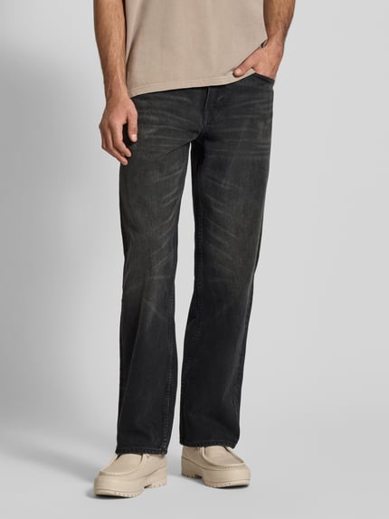 Mannenmodel draagt Jeans mit 5-Pocket-Design van Calvin Klein Jeans, rechte fit, pure katoen, donkere wassing, detailopname vooraan.