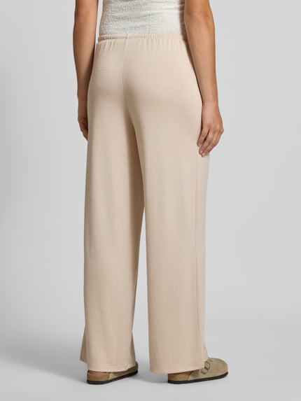 Frauenmodel trägt beige Gerade Hose Mit Viskose-Anteil Modell 'PIMI' von PIECES, lockerer Schnitt, glatte Oberfläche, Damen Gerade Hose, Ganzkörperansicht Rückansicht.