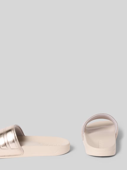 Produktfoto, Badeschuhe mit Metallic-Detail Modell 'ADILETTE SHOWER' von adidas Sportswear, efekt: jednolity kolor, zaokrąglony nosek, płaska podeszwa, metaliczny detal, bez zapięcia, podeszwa z fakturą