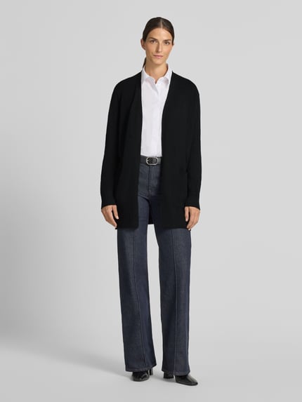 Frauenmodel trägt Relaxed Fit Strickjacke aus Viskose-Mix mit Eingrifftaschen von Christian Berg Woman, schwarze Farbe, gerippte Abschlüsse, langärmlig, Ganzkörperansicht von vorne.