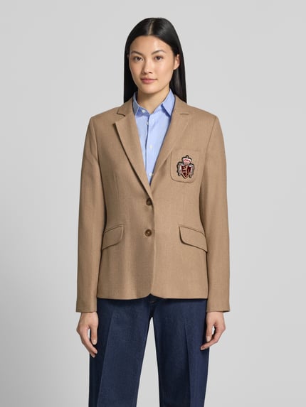 Vrouwenmodel draagt Blazer met Viskose-Anteil van MORE, zandkleur, elastische materiaalmix, getailleerd, borstzak met gestikt logo, 2-knoopsluiting, klepzakken, ruglengte maat 36: 65 cm, borstwijdte 42 cm, mouwlengte 64 cm, frontale opname van het hele lichaam.