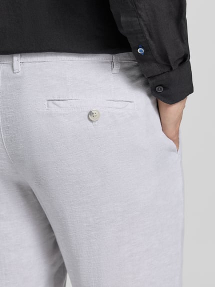 Männermodel trägt Hose aus Leinen-Viskose-Mix mit Eingrifftaschen von Christian Berg Men in Hellgrau, strukturierte Textur, Nahaufnahme Rückansicht. Regular Fit, sichtbare Gesäßtasche mit Knopf, Kontext: Bundweite 47 cm, Innenbeinlänge 78 cm bei Größe 50.