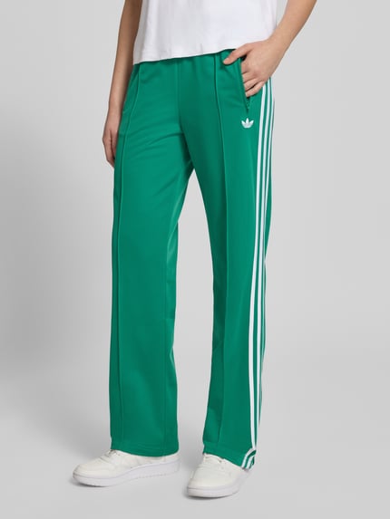 Frauenmodel trägt grüne Regular Fit Sweatpants mit Logo-Detail Modell 'FB CLASSIC TP' von adidas Originals, unifarben, Ganzkörperansicht von vorne.