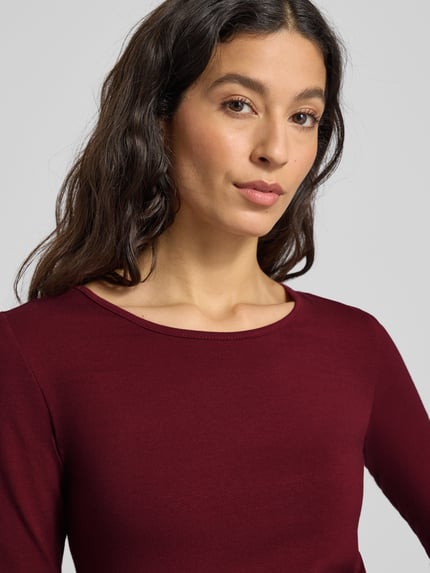 Modelka kobieca nosi Longsleeve mit geripptem Rundhalsausschnitt von ZABAIONE, bordowy kolor, Slim Fit, bawełna z elastanem, zbliżenie na górną część ciała.