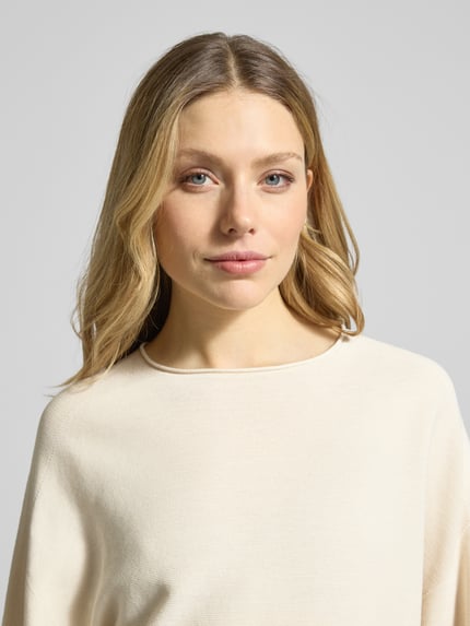 Frauenmodel trägt Strickpullover mit Rundhalsausschnitt Modell 'MEAMI' von Drykorn aus reiner Baumwolle im Relaxed-Fit, Nahaufnahme Oberkörper.