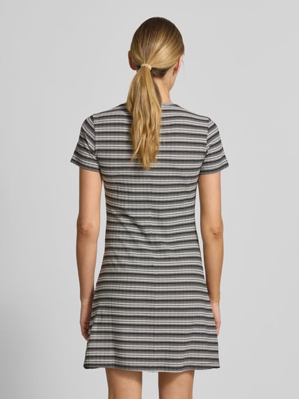 Frauenmodel trägt Körpernahes Freizeitkleid mit Allover-Muster von Tom Tailor Denim, Rippenstruktur, gerade Saum, Knielang, Kurzarm, Rundhals, Optik:Allover-Muster, Materialverarbeitung:Ripp, Ganzkörperansicht Rückansicht.