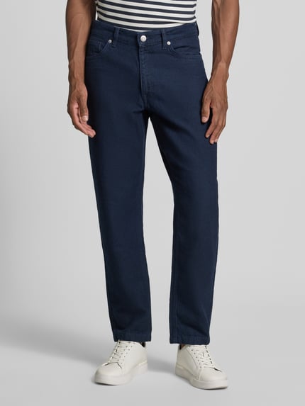 Männermodel trägt dunkelblaue Regular fit Tapered Jeans aus Baumwoll-Hanf-Mix Modell 'MAURO' von Selected, Herren Tapered Jeans, Nahaufnahme Oberkörper bis Füße.
