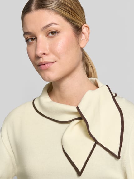 Frauenmodel trägt Strickpullover mit Schluppe Modell 'Sylena' von Neo Noir in Creme mit braunen Kontraststreifen, reine Baumwolle, Nahaufnahme Oberkörper.