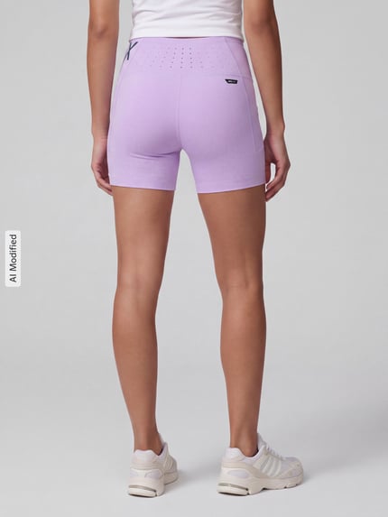 Frauenmodel trägt Skinny Fit Sportshorts mit Label-Print Modell 'PUMA x HYROX PWRMODE 4' von PUMA, Damen Sportshorts, Ganzkörperansicht Rückansicht, KI-modifiziertes Bild.