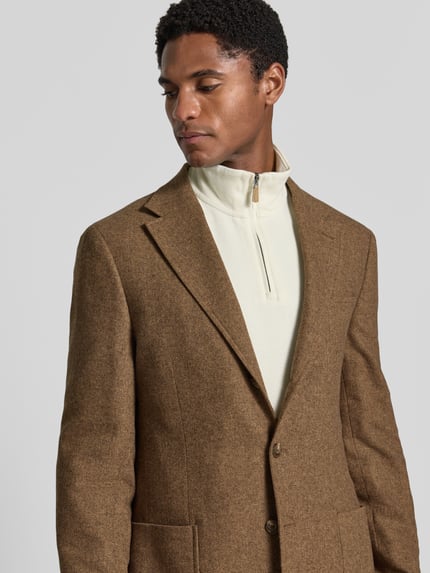 Männermodel trägt Modern Fit Sakko mit Woll-Anteil Modell 'HERRINGBONE' von Polo Ralph Lauren in Braun, Nahaufnahme Oberkörper.