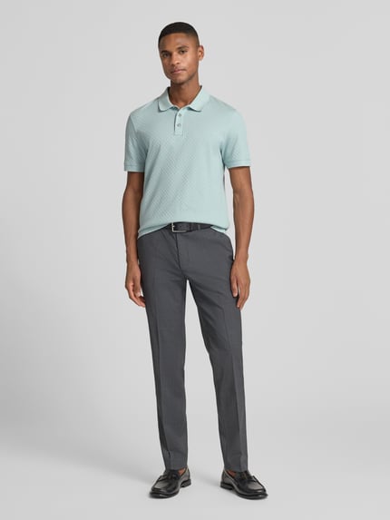 Männermodel trägt Poloshirt mit kurzer Knopfleiste Modell 'Roni' von JOOP! Collection, hellgrün, klassische Passform, Ganzkörperansicht von vorne.