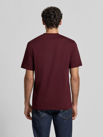 Männermodel trägt Regular Fit T-Shirt aus reiner Baumwolle von Lacoste in Dunkelrot, glatte Textur, Ganzkörperansicht Rückansicht.