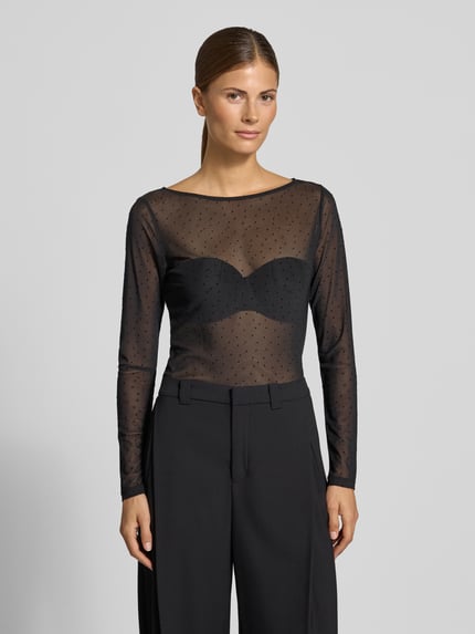 Frauenmodel trägt Slim Fit Longsleeve mit Punktemuster Modell 'OKTOBER' von COMMA, transparentes Schwarz mit eingefassten Abschlüssen, Ganzkörperansicht von vorne, Rückenlänge bei Größe 36: 55 cm.