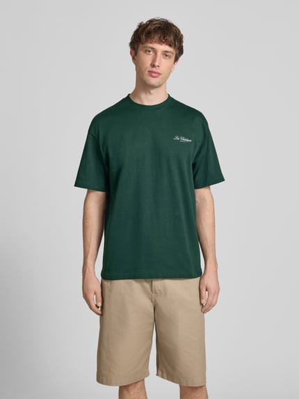 Mężczyznę model nosi Loose Fit T-Shirt aus reiner Baumwolle Modell 'LES CLASSIQUES' von Only & Sons, efekt: jednolity kolor, krój loose fit, aplikacja: napis, okrągły dekolt, rękaw: krótki rękaw, wykończenie materiału: dżersej, Ganzkörperansicht von vorne